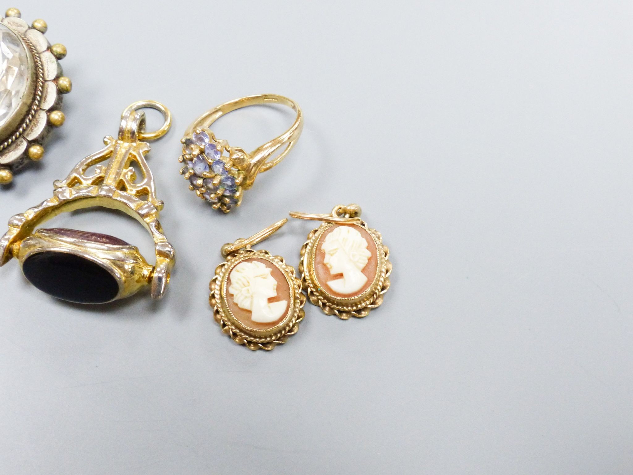 A 9ct gold cameo ring, a pair of similar earrings, yellow metal settings, a 9ct gold gem-set ring, a 'fob seal' pendant, a silver-gilt butterfly pendant and a clear paste-set pendant